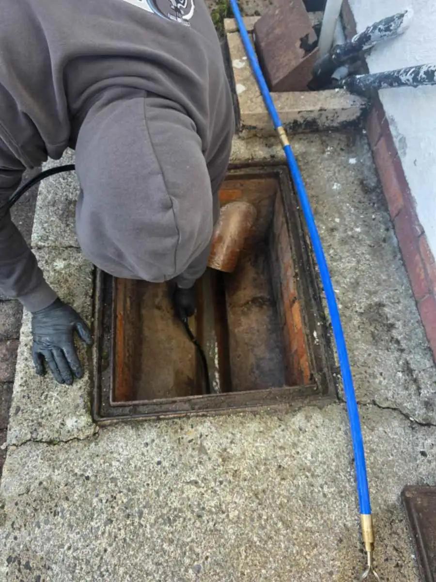 Stephen clearing a blocked outside drain in Carlisle, Cumbria.