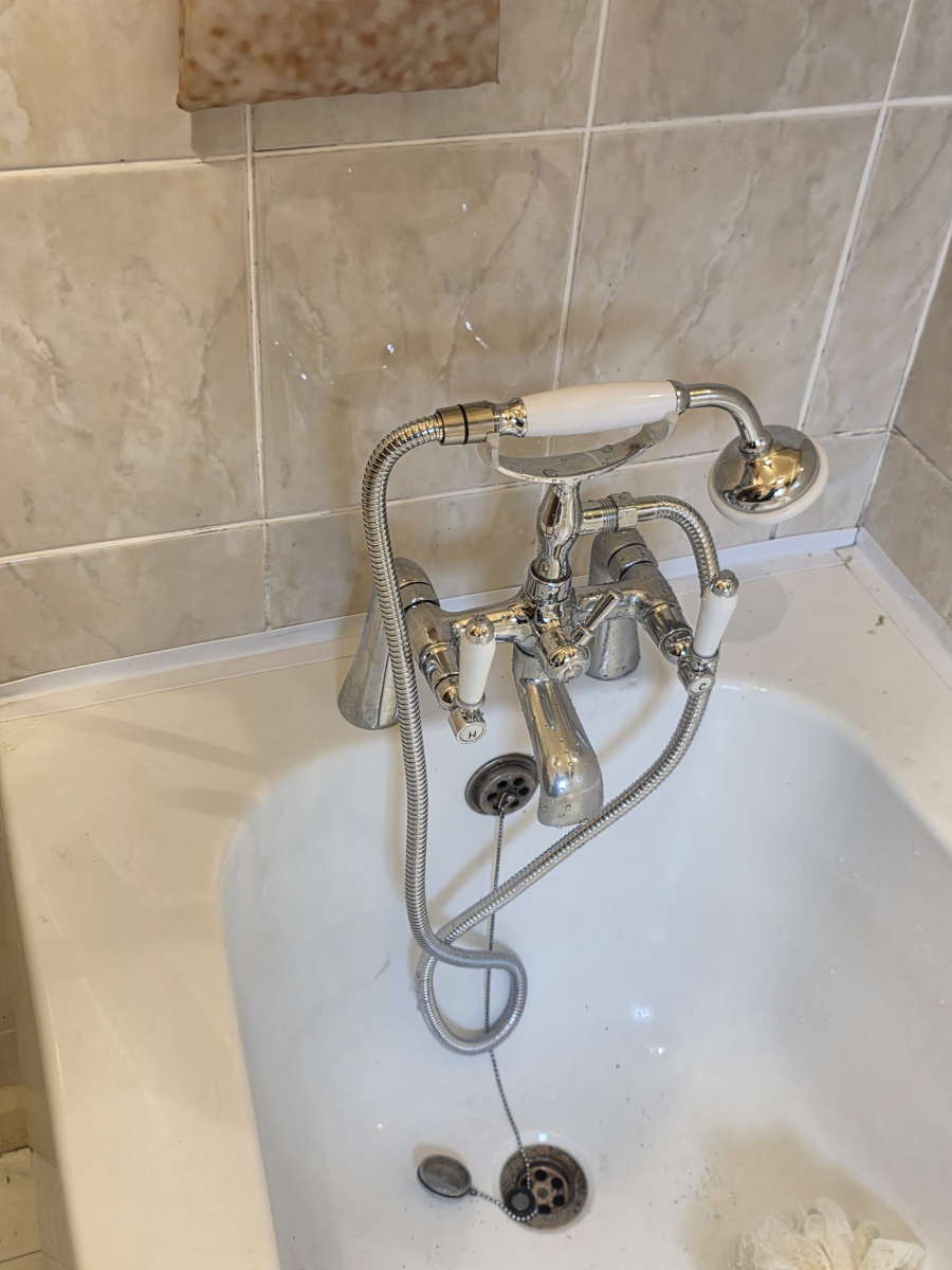 Glass shower screen fitted over a bathtub in a Carlisle bathroom.