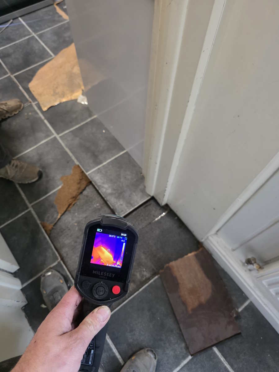 Engineer using a thermal camera to trace heat loss on a wall in Carlisle.