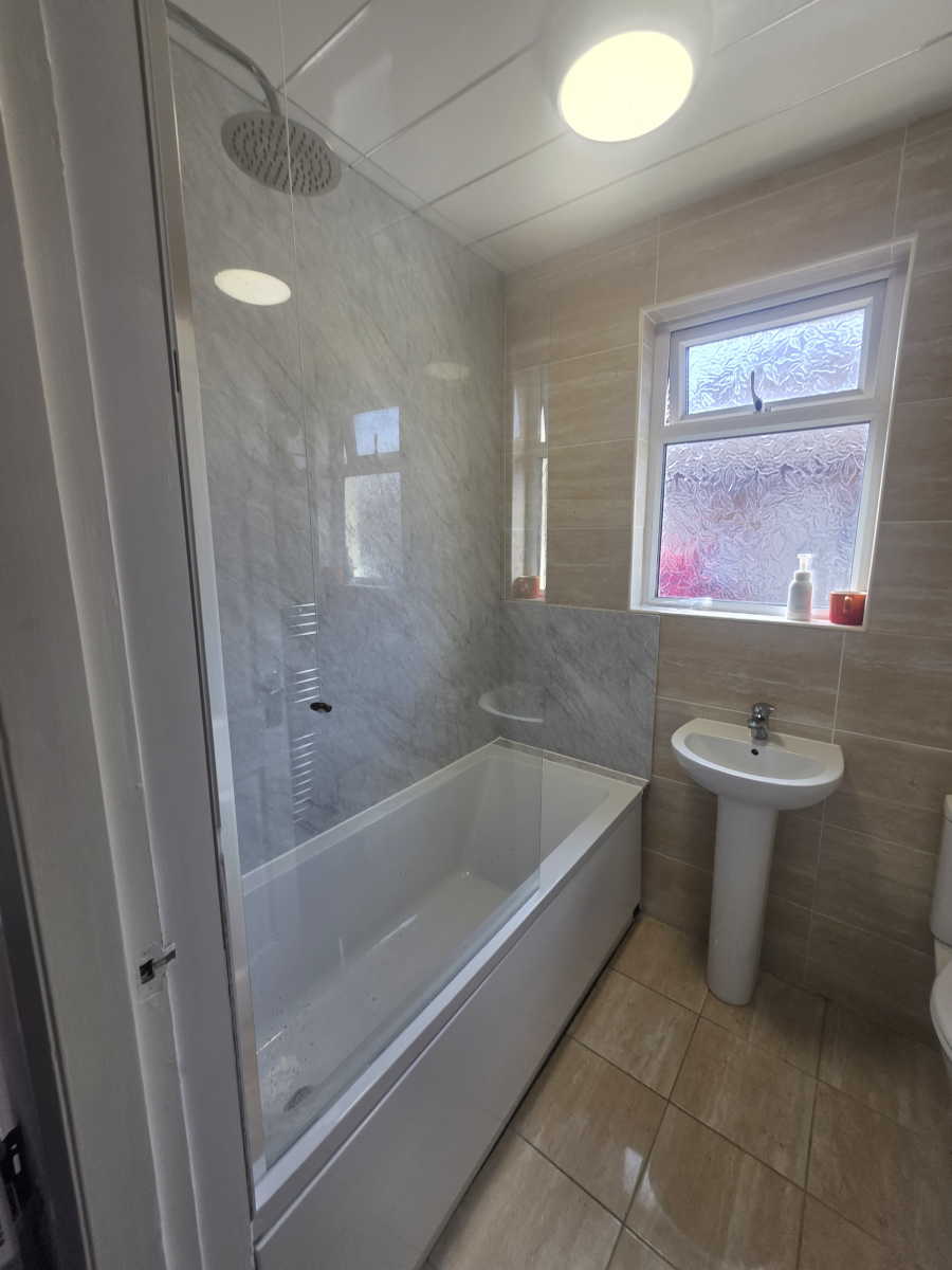 Modern bathroom with brown feature tiles and white bath wall tiles in Carlisle.